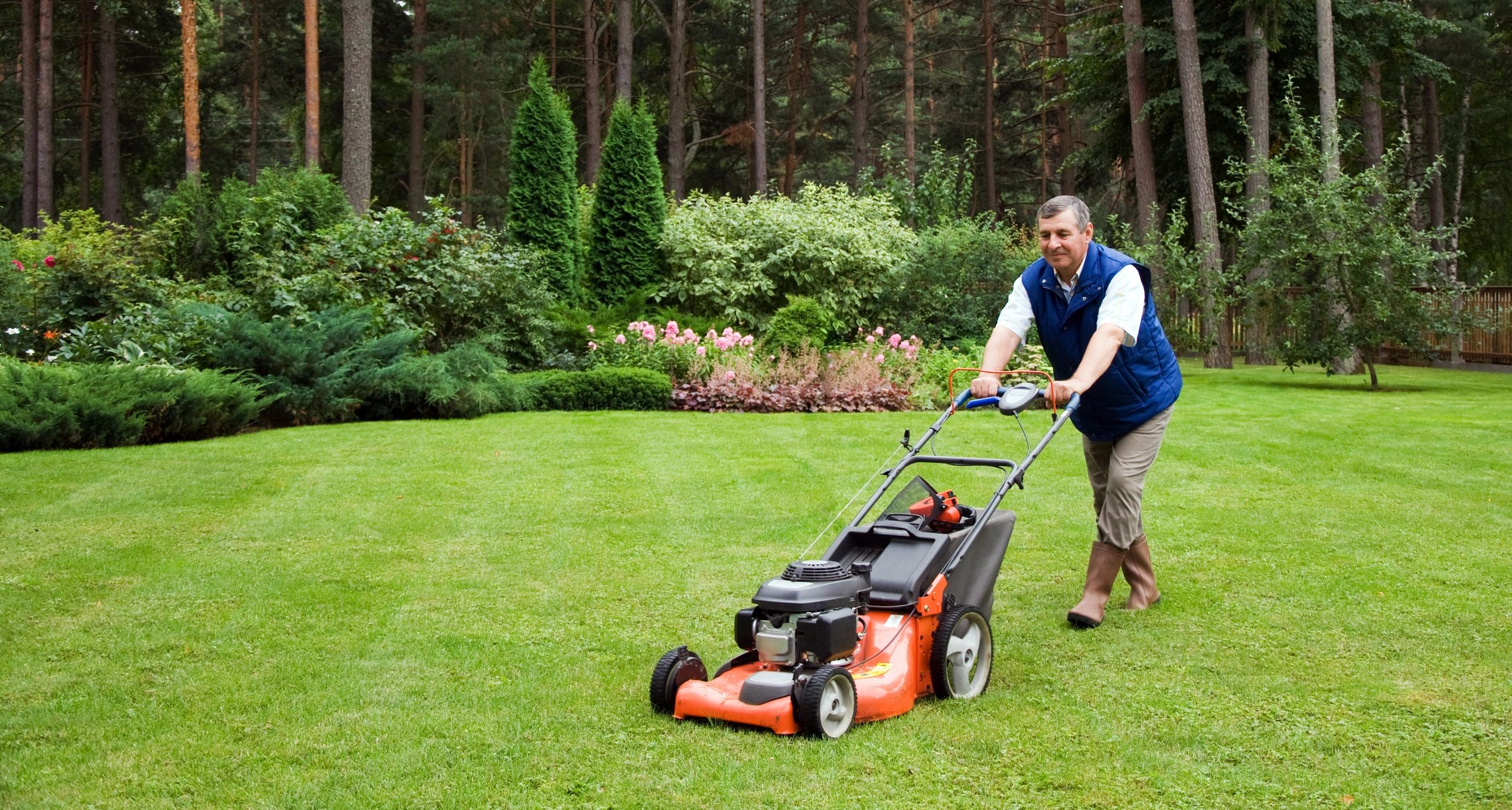 Customer smiling in front of a well-maintained garden